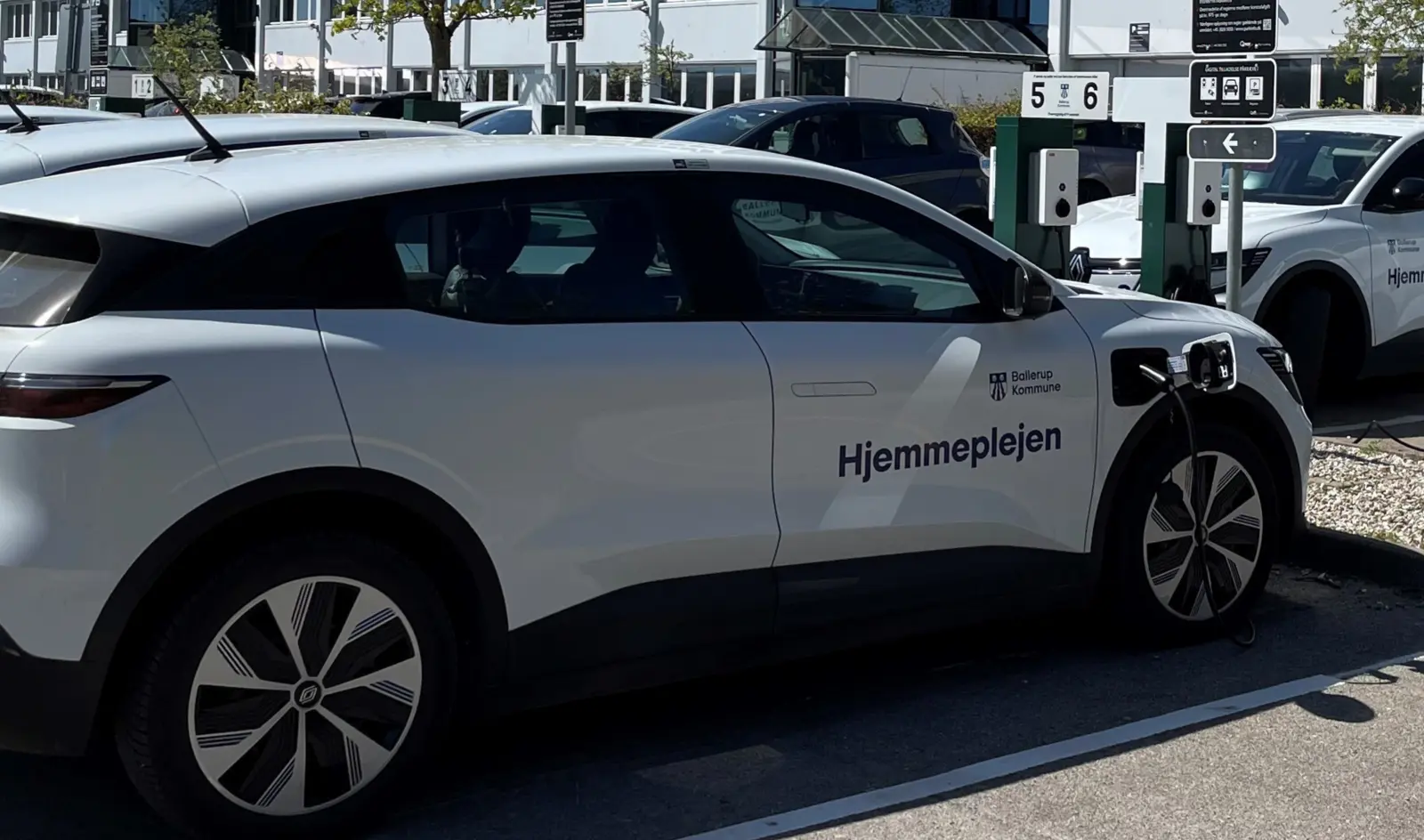 Hjemmeplejebil ved ladestander før et hjemmebesøg